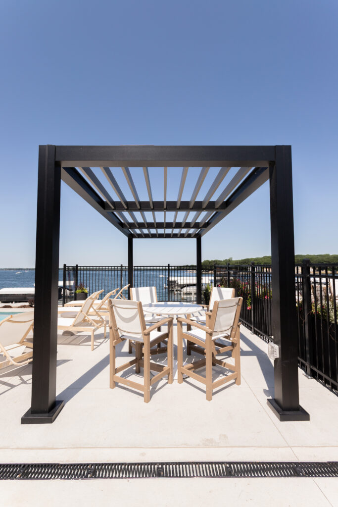 R-BREEZE pergola with fixed louvers at a lakeside patio