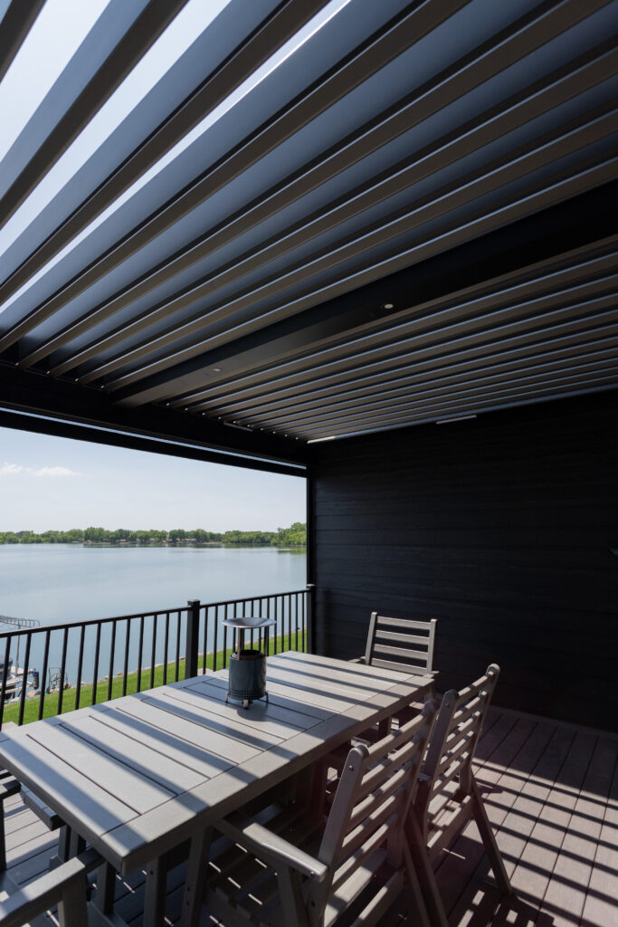 R-BLADE pergola with motorized louvers covers a lakeside deck