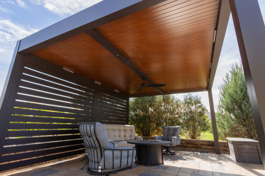 solid roof pergola with insulated panels covers a pool-side patio space