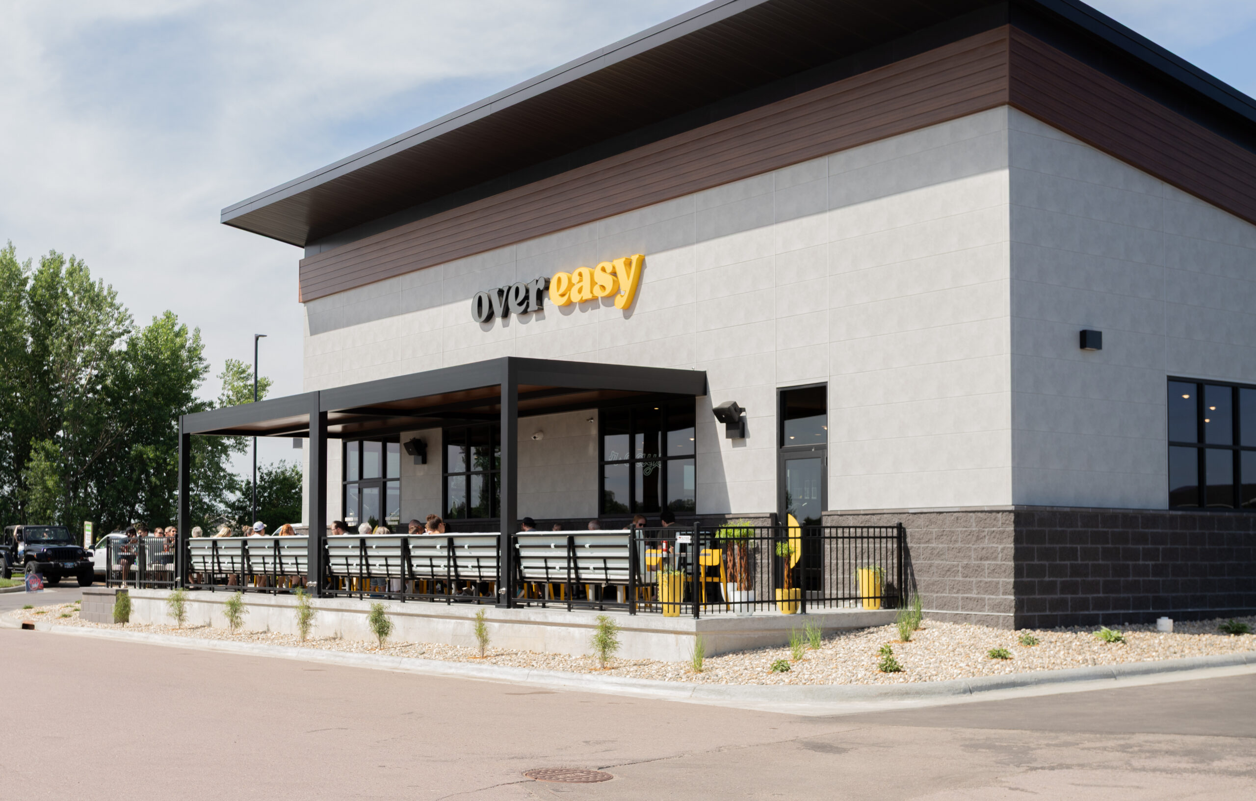 restaurant patio with customers dining under a solid roof pergola